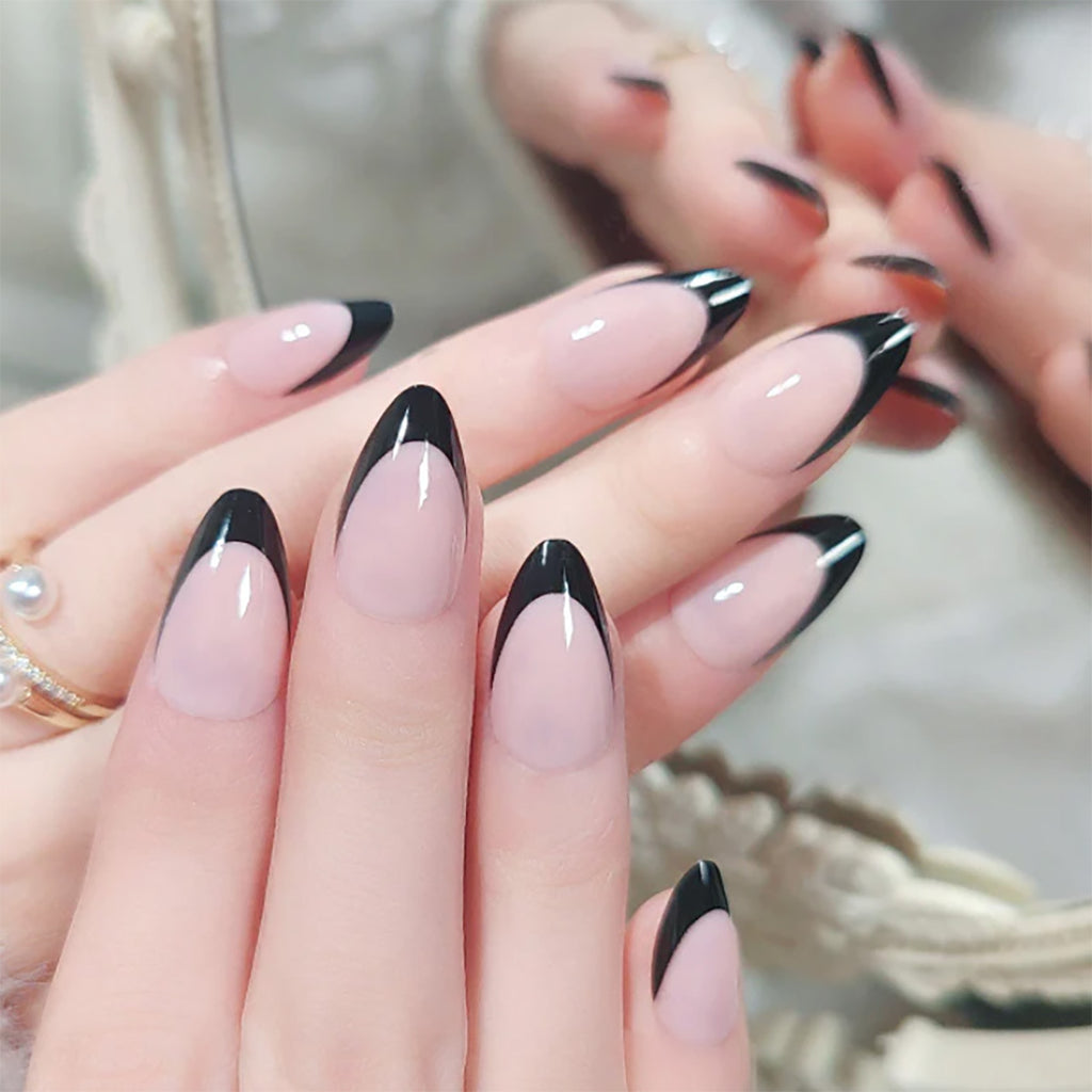 Nude press-on nails with glossy black French tips on long oval shapes