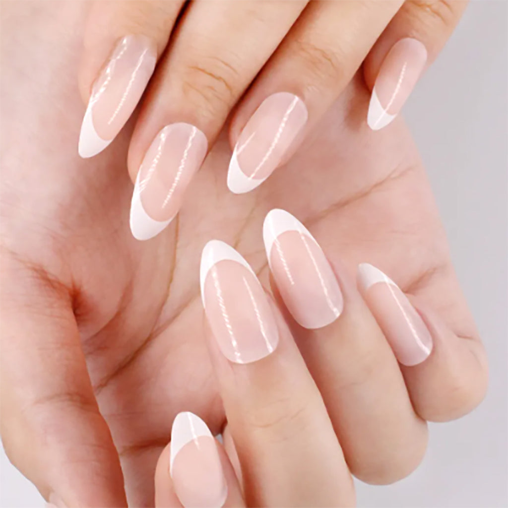 Sheer pink press-on nails with white French tips on long oval shapes