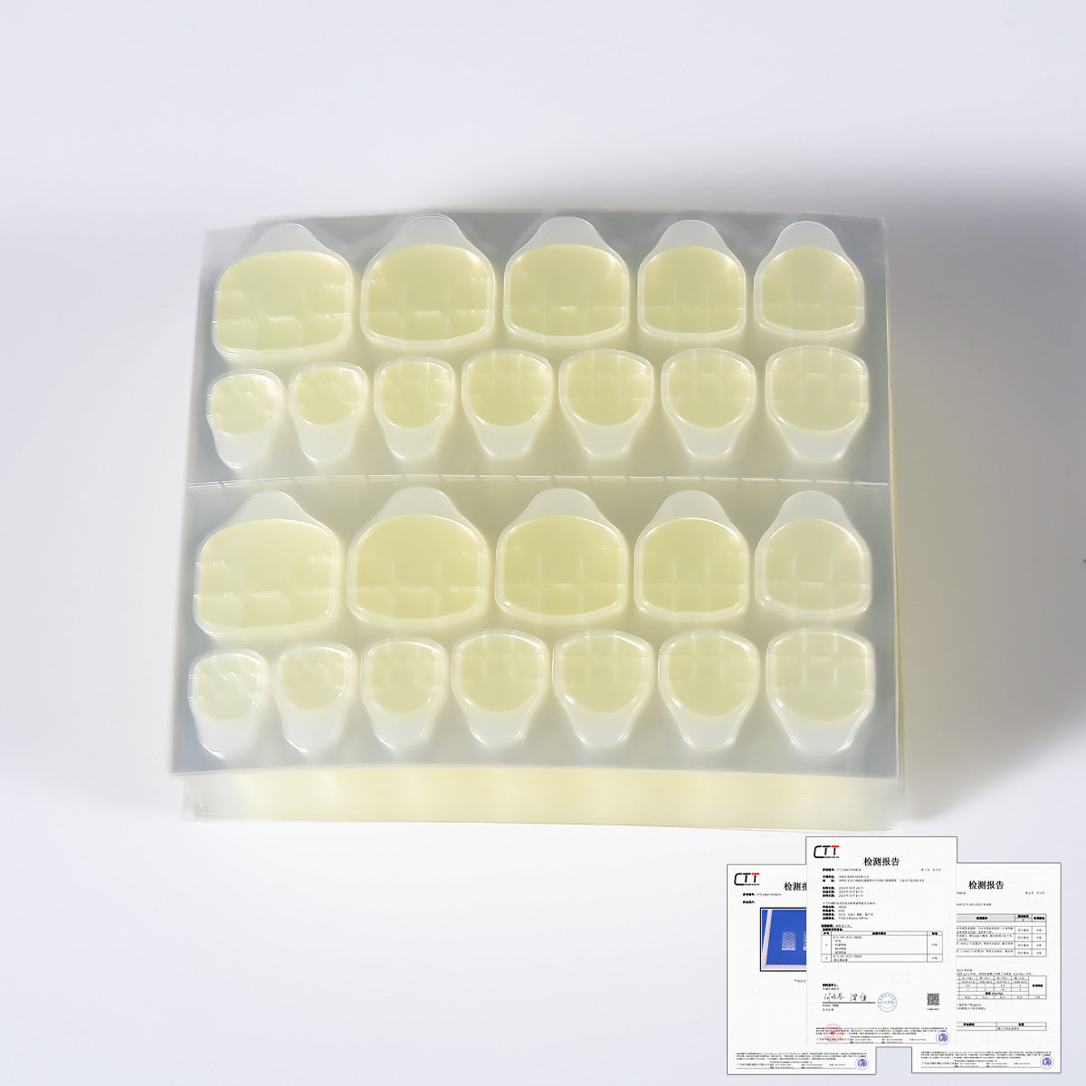 Yellow nail jelly glue tips set in clear tray, neatly arranged square shapes