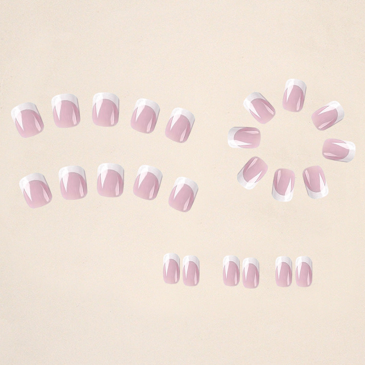 Set of false nails arranged: sheer pink with white French tips and small glitter dots