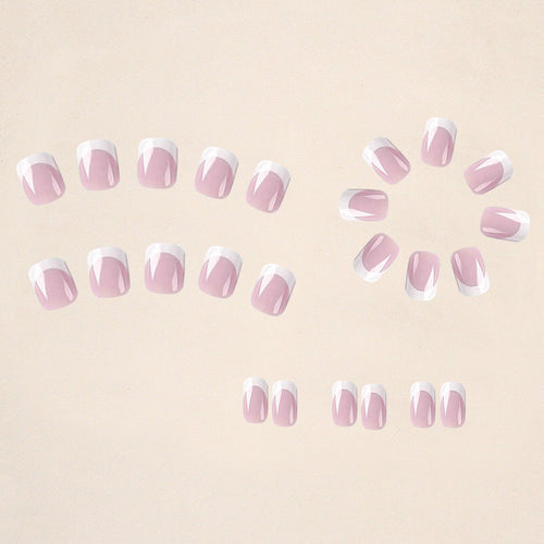 Set of false nails arranged: sheer pink with white French tips and small glitter dots